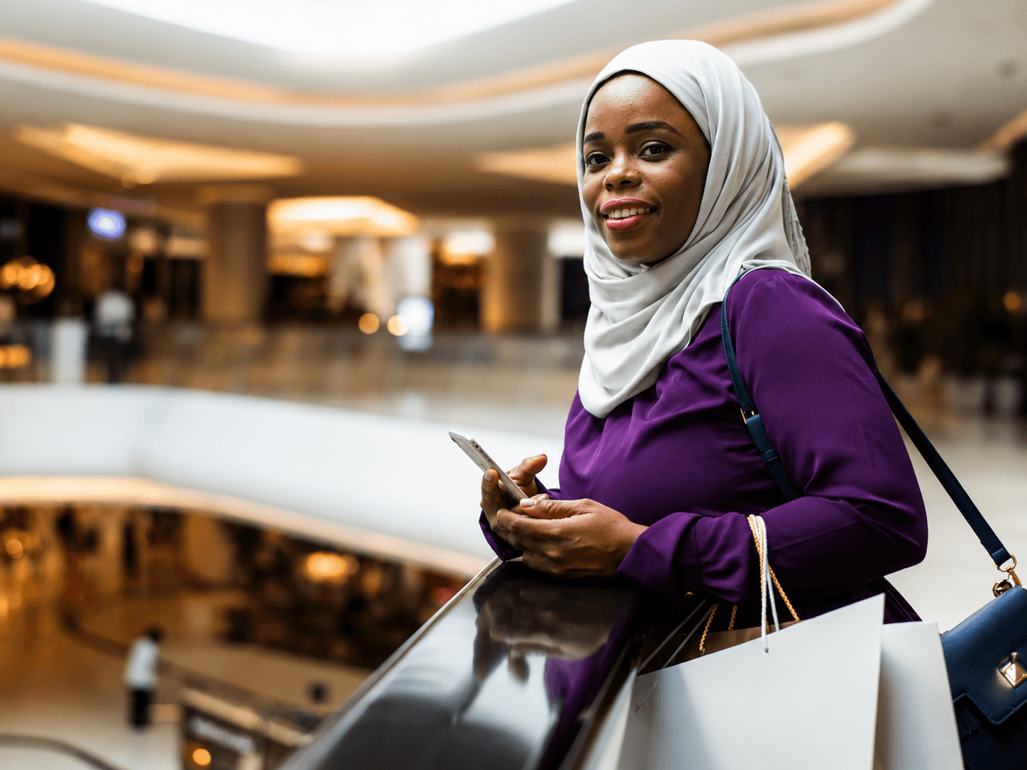A shopper carrying bags inside the mall