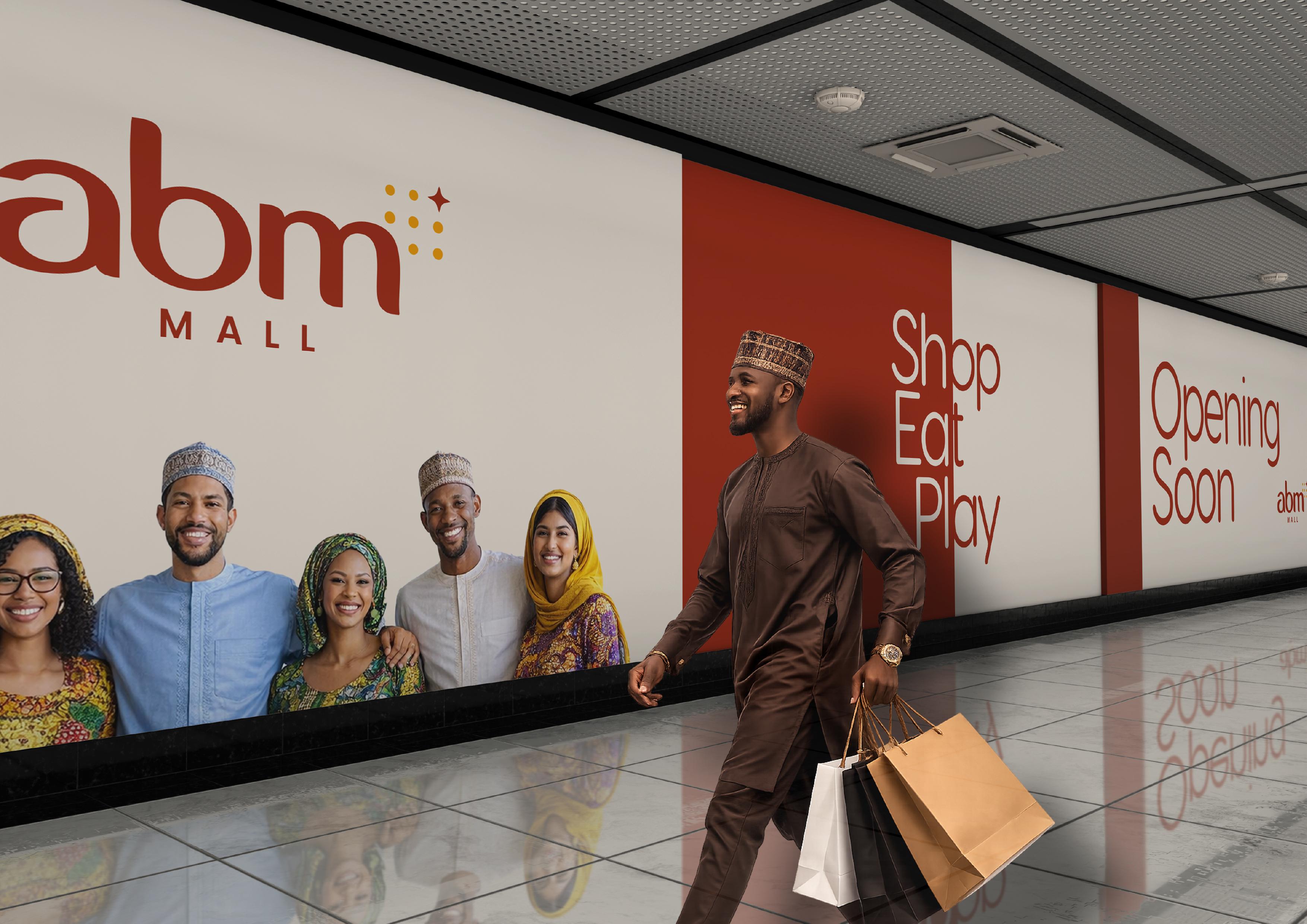 Shoppers posing in front of the ABM Mall entrance, with a man walking past carrying shopping bags