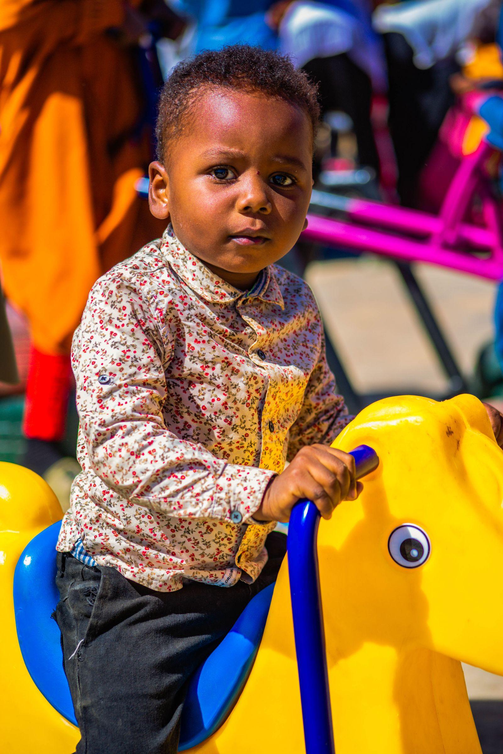 A child riding a colourful playground ride