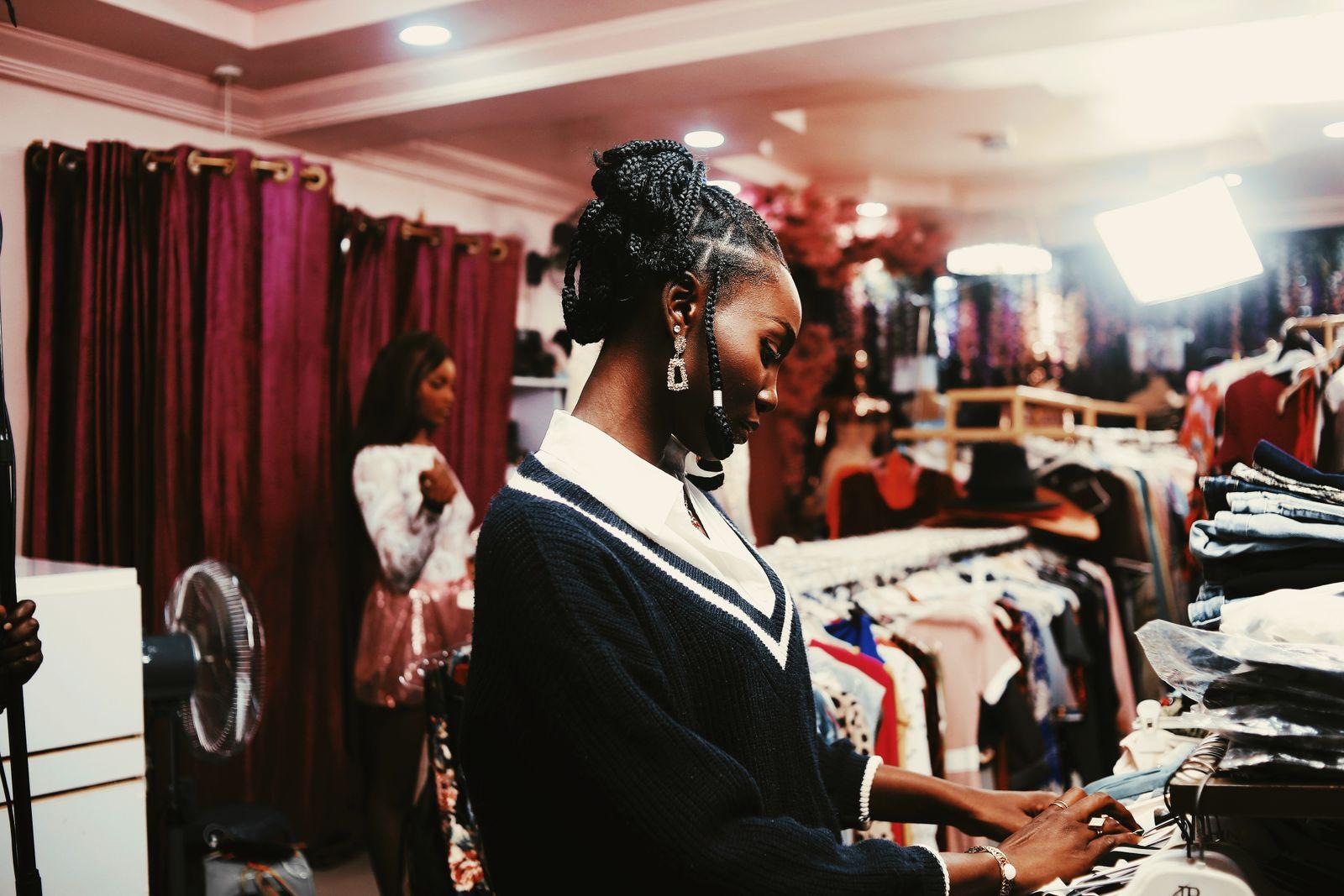 A shopper browsing racks of clothing in a boutique
