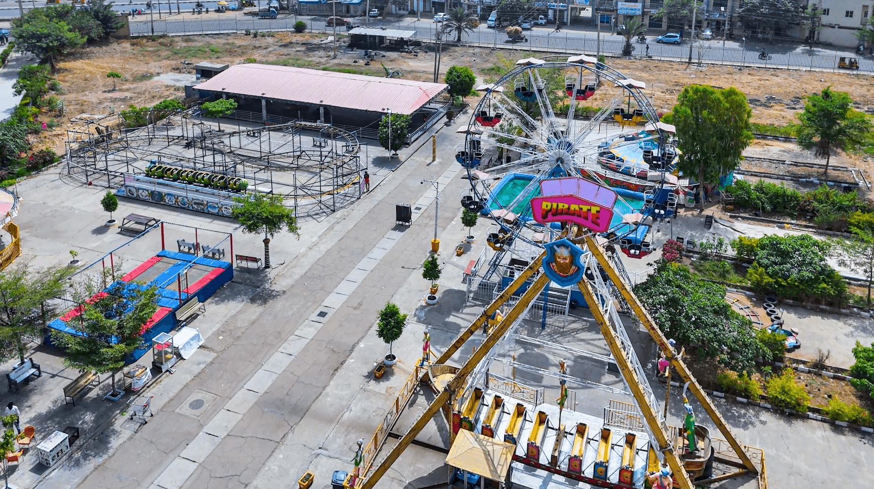 An aerial view of a Ferris wheel and pirate-themed ride at ABM Mall's fairground