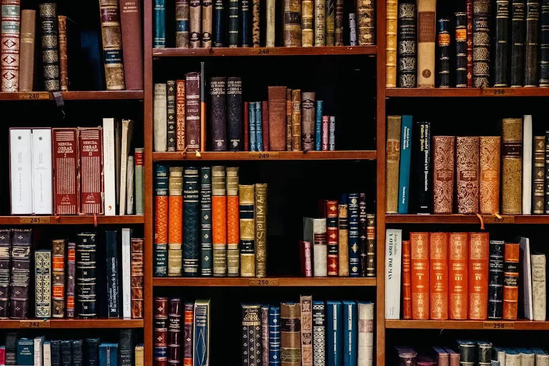 A densely packed bookshelf of hardcover books