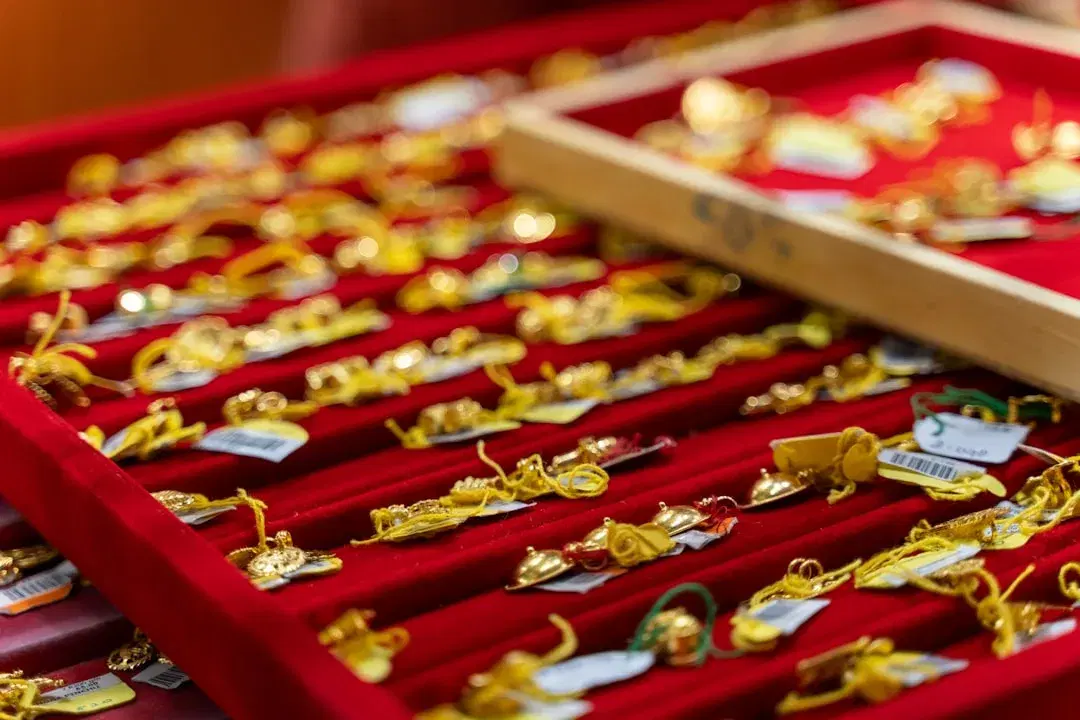 Rows of gold rings and pendants displayed on velvet trays